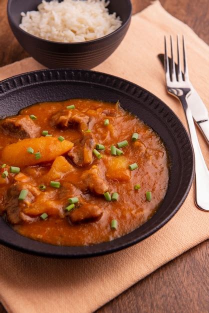 Premium Photo Plate With Cooked Cassava And Meat On Wooden Table