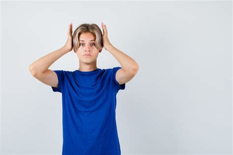 Muchacho Adolescente Joven Con Las Manos En La Cabeza En Camiseta Azul