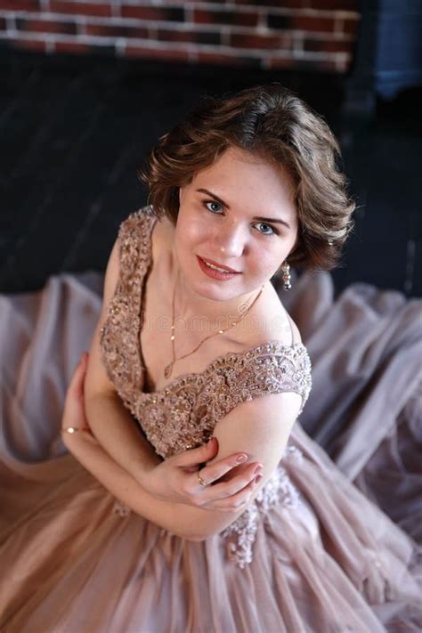 The Girl The Brunette In A Beautiful Dress Poses Sitting On A Floor Stock Photo Image Of