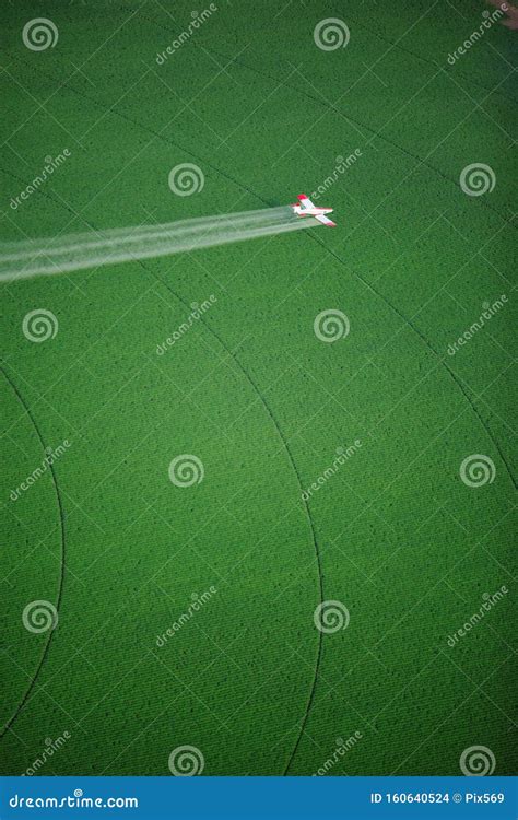 A Crop Duster Spraying a Green Farm Field. Stock Photo - Image of farming, crop: 160640524