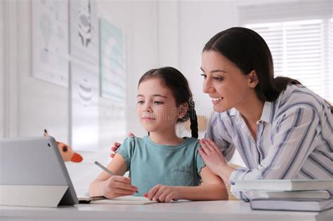 Mère Aidant Sa Fille à Faire Ses Devoirs Avec La Tablette à La Maison