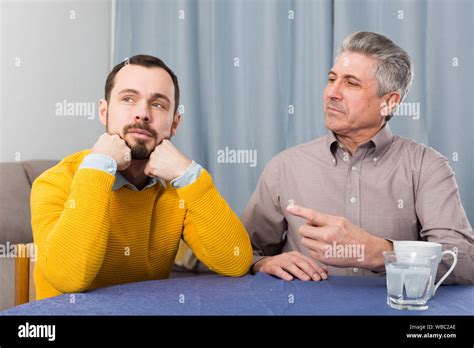 Mature Father And His Son Are Serious Conversation At Home And Solve Problems Stock Photo Alamy