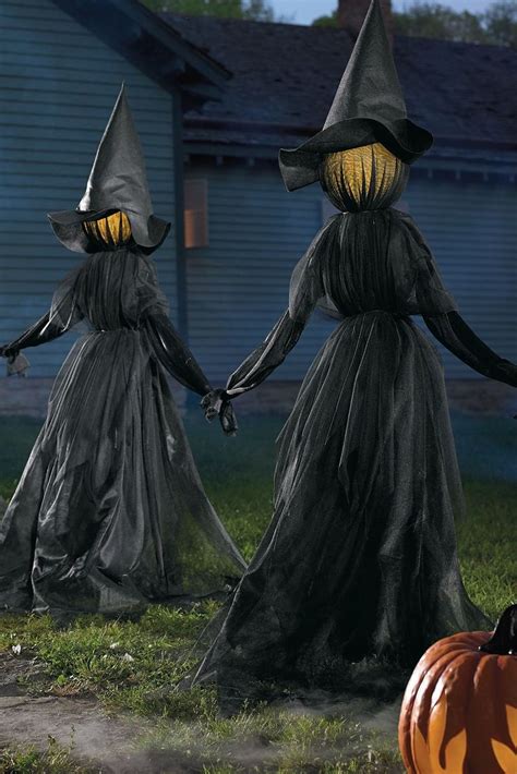 Three Halloween Witches Walking In Front Of A House With Pumpkins On