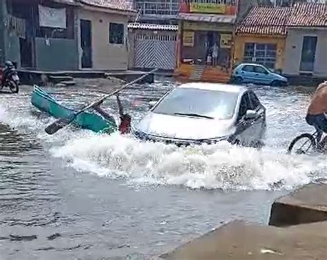 Homem cai de canoa após quase ser atingido por carro em rua alagada de