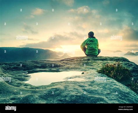 Man Sitting On Cliff Edge