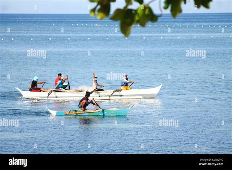 Filipino Fishermen Riding The Traditional Wooden Fishing Boat Called