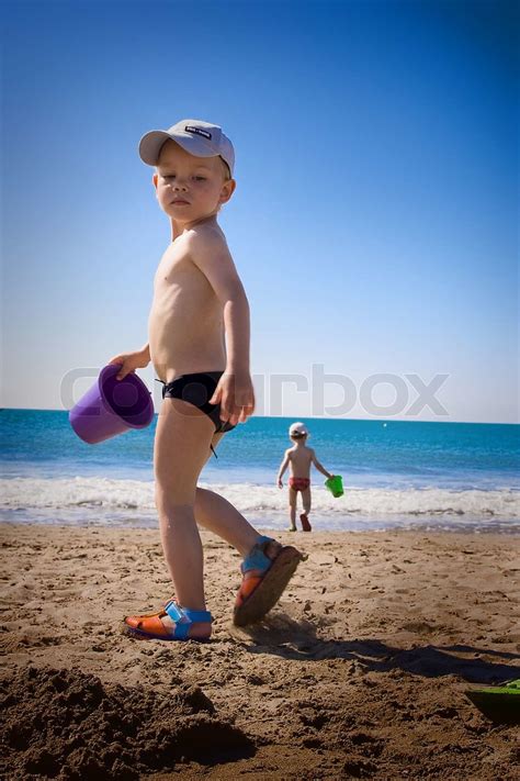 To små børn der leger på stranden Stock foto Colourbox