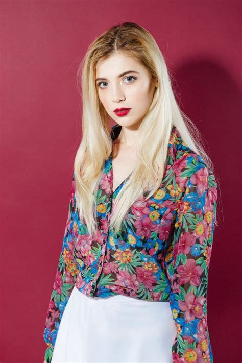 Portrait Of Sensual Blonde Model With Long Hair In Colorful Shirt And White Skirt Is Looking At