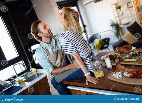 Happy Couple Cooking Together Husband And Wife In Their Kitchen At Home Preparing Healthy Food