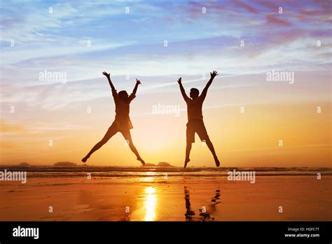 Pareja Feliz Saltando Por La Playa Al Atardecer La Familia Vacaciones