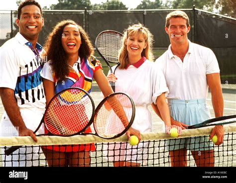 Black white couples playing tennis together Stock Photo - Alamy