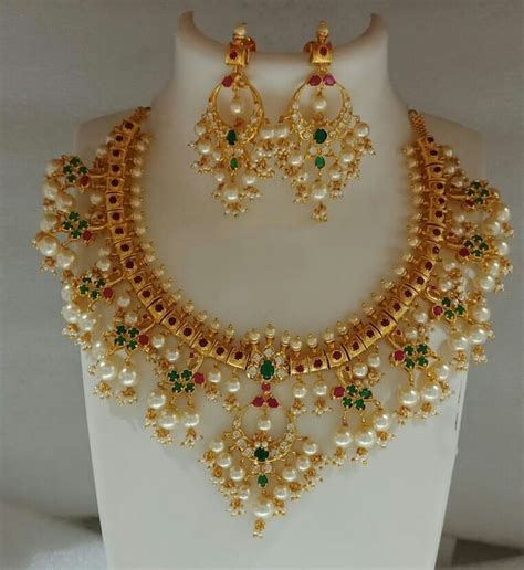 A White Mannequin With Green And Red Stones On The Neck Necklace And