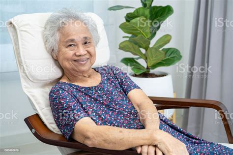 Asian Elderly Woman Sitting And Relaxing With Happy In Rocking Chair At