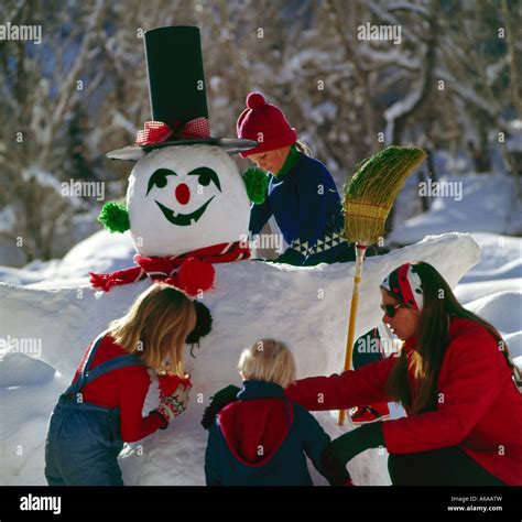 Mom and kids building a snowman on a chilly Winter day Stock Photo - Alamy