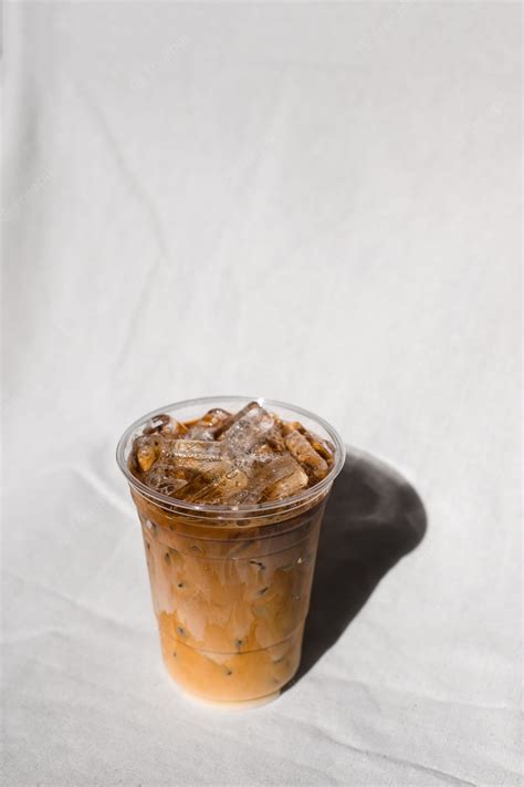 Premium Photo Closeup Plastic Glass Of Iced Coffee With Milk On The Table