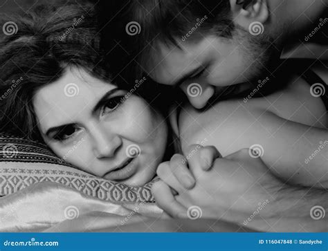 Young Beautiful Loving Couple is Embracing on a Bed. Ntimate Image of