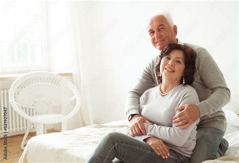Mature Year Old Couple Hugging While Sitting On The Bed In The Bedroom Love Forever Stock