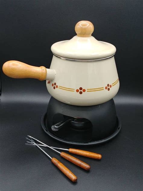 A Tea Pot With Wooden Spoons Sitting On Top Of It