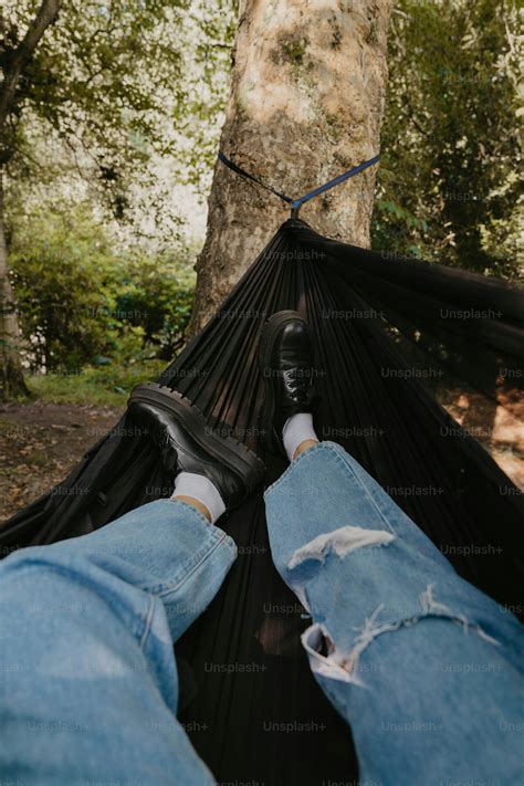 A Person Laying In A Hammock In A Forest Photo Relaxed Image On Unsplash