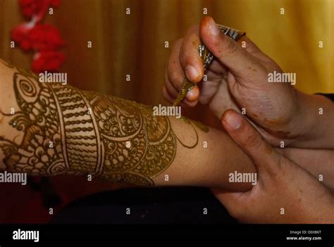 Hand Painting Traditional Designs In Henna On A Brides Arm For An