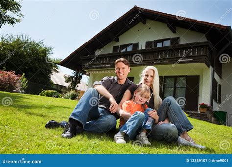 Famille S asseyant Devant Leur Maison Image stock Image du marié