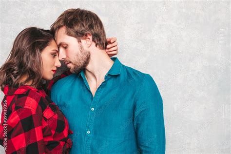 Hot Beautiful Woman And Her Handsome Boyfriend Models Posing Near Gray Wall In Jeans Clothes