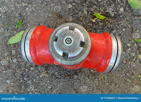 Red Metal Fire Hydrant On A Background Of Old Gray Asphalt Top View