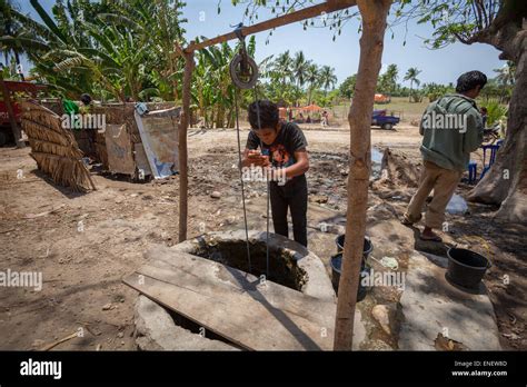 A Villager Lifting Water From A Communal Water Well During Dry Season