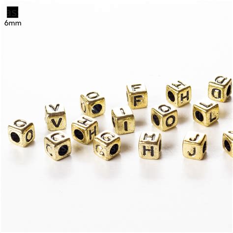 Entremeio Quadrado 6mm Dourado Letras Sortidas em Preto Sóstrass