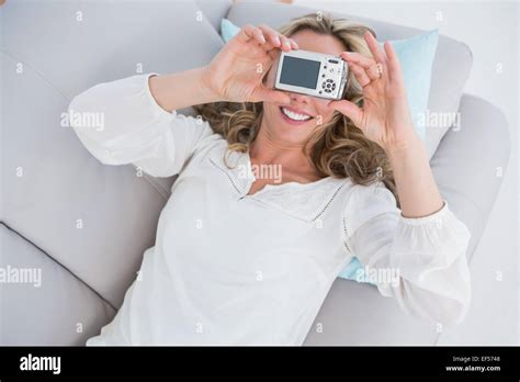 Smiling Blonde Lying On Couch Taking A Selfie Stock Photo Alamy