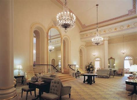 an elegant living room with chandelier, couches and tables in it's center