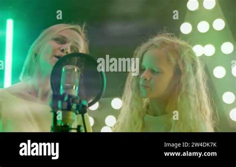 Mom And Daughter Are Engaged In Singing Into Microphone In Karaoke Club