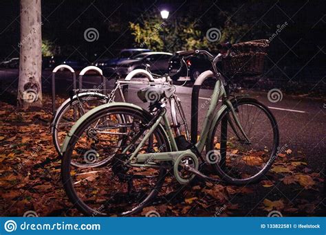 Dos Bicicletas Del Vintage Parqueadas En La Calle En La Noche Imagen De