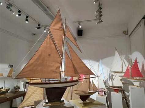 Several Model Sailboats Are On Display In A Room With White Walls And