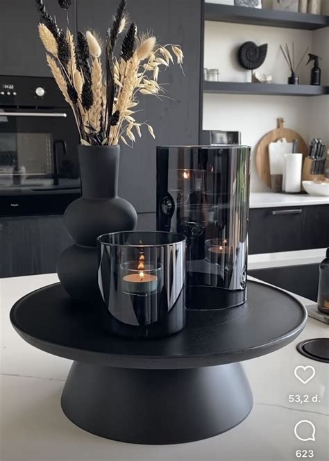 A Black Table With Two Vases Filled With Flowers And Candles Sitting On