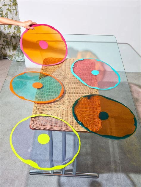 A Glass Table Topped With Lots Of Different Colored Plates