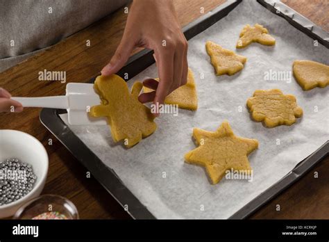 Mid Section Of Man Placing Gingerbread Cookies In Baking Tray Stock