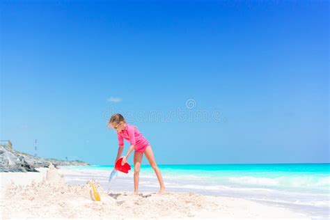 Adorable Little Girl Playing with Beach Toys in Shallow Water Stock ...