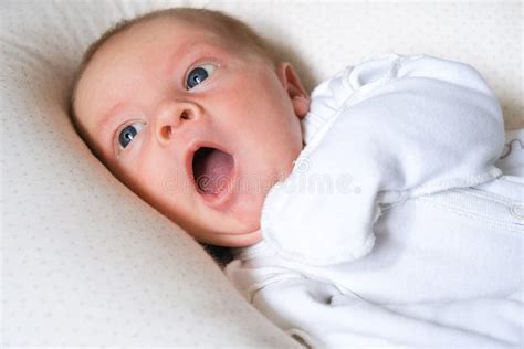 Yawning Cute Newborn Baby Boy Lying In Bed Trying To Sleep Baby