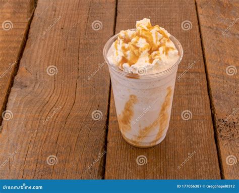 Blended Iced Coffee Caramel Frappe In A Plastic Cup With Whipping Cream