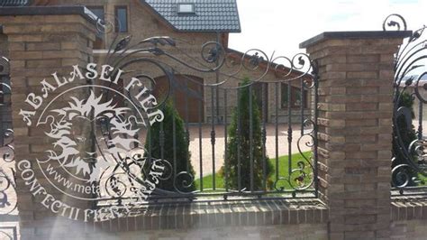 An Iron Gate With The Words Royal Mail On It And Some Bushes Behind It