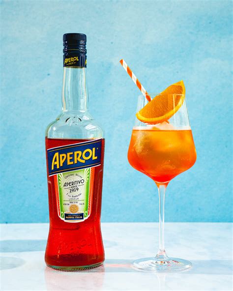 A Bottle Of Aperol Next To A Glass With An Orange Slice