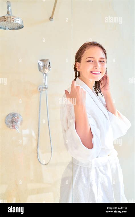 Photo Of Happy Brunette Woman With Wet Hair In White Bathrobe Looking At Camera While Standing