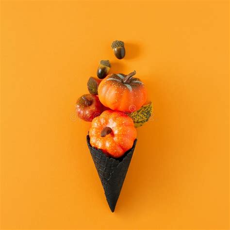 Creative Flat Lay With Pumpkins And Black Ice Cream Cone On Orange