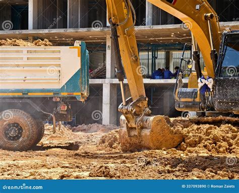 Excavator Loads Ground Into A Dump Truck At A Construction Site Stock