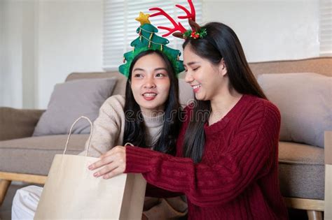 Tender Moment Between Interracial Lesbian Couple During Festive Gift Sharing Stock Photo Image