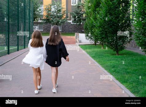 Fraternal Twins Sisters Blonde And Brunette Teen Girls In Fashionable Black And White Clothes