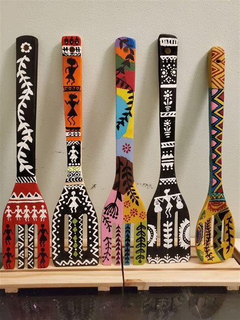 Four Colorful Wooden Spoons Are Lined Up On A Shelf In Front Of A Wall