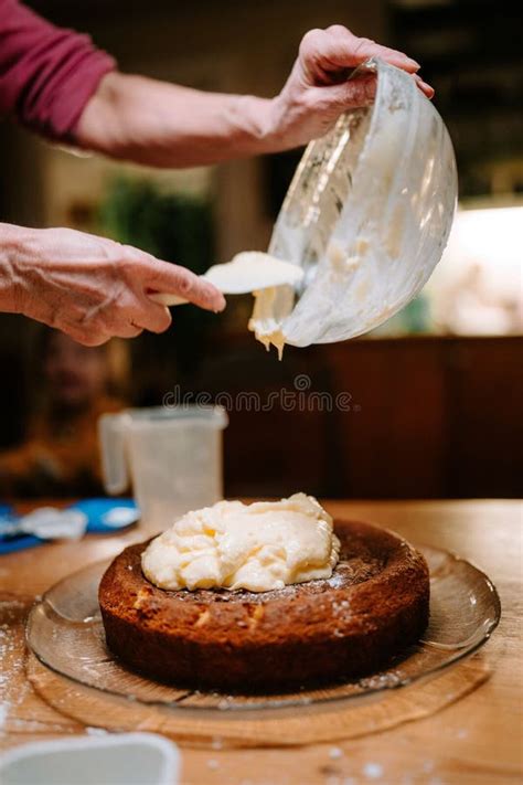 Person Adding A Finishing Touch To A Delicious Cake By Placing A Cream