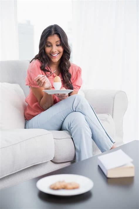 Happy Cute Brunette Sitting On Couch Holding Hard Boiled Egg Stock Image Image Of Long Lounge